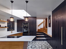 Küche im Retro-Stil mit schwarzen Bretterfronten und Musterfliesen