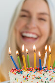 Woman smiling behind birthday candles