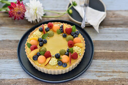 Vegan tutti-frutti summer tart with peach and blueberry cream
