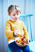Boy eating slow cooker sausage casserole