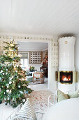 Decorated Christmas tree and Swedish tiled stove in rustic living room