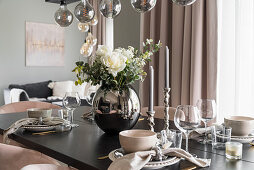 Vase of flowers on elegantly set dining table