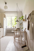 Table with two chairs in bright kitchen with white oiled wooden floor