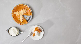Pumpkin pie, cut and served with cream