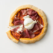 Wholemeal pizza with cured ham and burrata