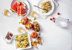 Various summer dishes on a white surface