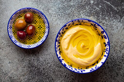 Delicious hummus served with olives in olive oil