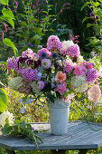 Fragrant late summer bouquet with phlox, dahlias, hydrangeas, roses, bluebells, amaranth, sweet peas and thistles in a vase that is too small