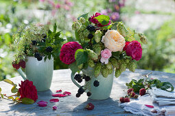 Small autumn bouquets with roses, hops, blackberries, fennel umbels and raspberries in coffee cups