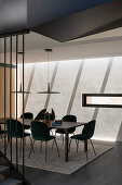 Dark green velvet chairs at long table in modern dining room