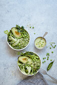 Green bowls with broccoli 'rice', avocado, edamame and pea dressing