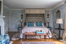 A double bed in a bedroom with 1930s Art Deco-style chinoiserie wallpaper