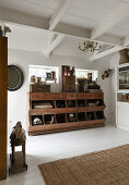 An antique wooden cabinet with drawers and shelves in a room with white floorboards
