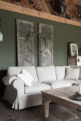 Sofa mit naturweißer Husse vor Vintage Türen an der Wand