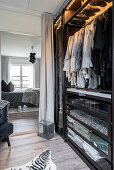 A walk-in wardrobe with access to a bedroom