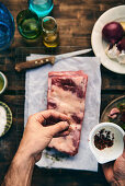 Raw spare ribs being seasoned