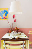 A hanging lamp above a kitchen table with garden chairs