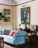 Hellblaues Sofa und Sessel mit Stickerei im Salon mit Kunstwerken an den Wänden