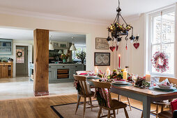 Lit candles on dinding table in open plan dining room kitchen of Regency home