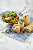 Feta cheese and sesame seed rolls with a tomato salad