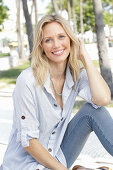 A blonde woman wearing a light-blue striped shirt and jeans