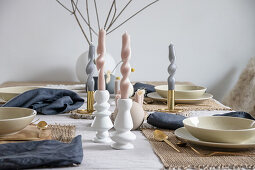 Arrangement of artistically twisted, pastel-coloured candles on table