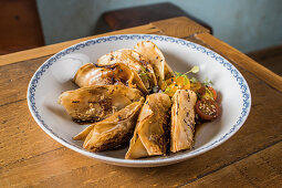 Plate with traditional Asian gyozas filled with vegetables and served with Sriracha hot sauce with mustard and soy