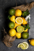 Still life of limes and lemons basket placed on dark textured surface