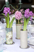 Vases of hyacinths, waxflowers and broom decorating table