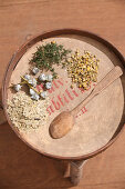 Different dried herbs on an antique wooden tray