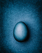 Blue-gray Easter egg on a gray-blue background