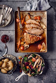 Crispy roast pork with oven-roasted vegetables and new potatoes
