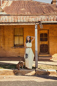 A grey-haired woman wearing a summer dress with a dog