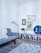 Classic sofa, floor lamp and shelves below works of art in the living room