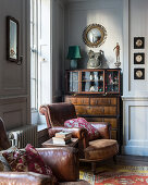 Brown leather armchair in front of antique cabinet in living room