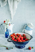 Frische Erdbeeren in dunkelblauem Seiher