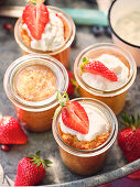 Rum mugcake in a glass with cream and strawberries
