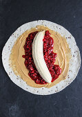 A fruit and peanut butter wrap with bananas and raspberries