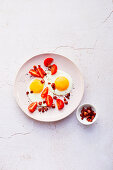 Fried eggs with diced bacon and tomatoes