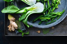 Asian vegetables in a sheet metal bowl on a sheet metal background