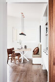 View into modern dining room in natural shades with wooden floor