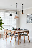 Various lamps above dining table and wooden upholstered chairs