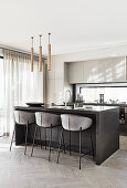 Upholstered bar stools at island counter in modern kitchen decorated in grey