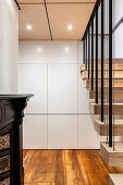 Practical fitted cupboards with white fronts under the stairs