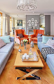 Orange armchairs in elegant, open-plan, classic interior