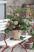 Weihnachtsstrauß aus Zweigen von Nordmanntanne, Kiefer, und Zierapfel, mit Strohsternen geschmückt