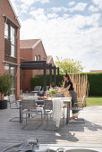 Woman arranging flowers on the garden table on the terrace