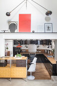 Küchenzeile mit schwarzen Fronten und Holzarbeitsplatte in Loft-Wohnung