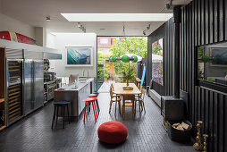 Open plan family home with timber clad walls and wood burning stove