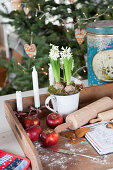 Wooden tray with apples, candles, hyacinths, rolling pin, and recipe card